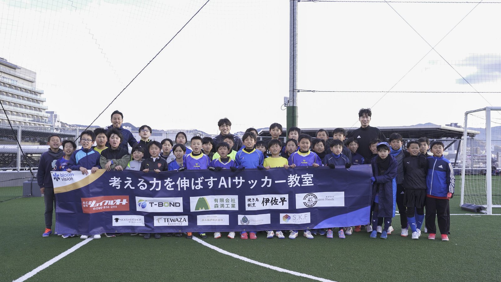 AIサッカー教室「考える力を伸ばす」の集合写真。参加した子どもたちと講師陣。
